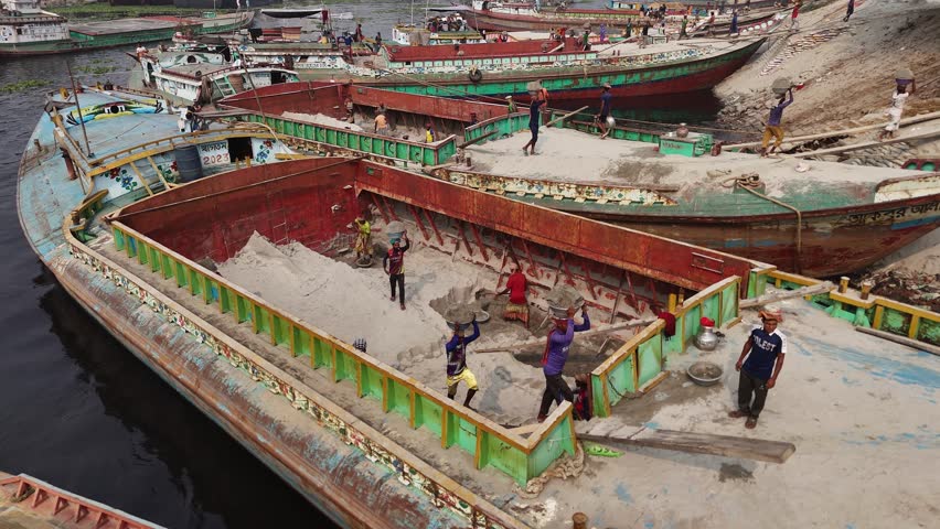 Dhaka, Bangladesh - 01 April 2025: Aerial view of bustling factory by Buriganga River, Bangladesh.