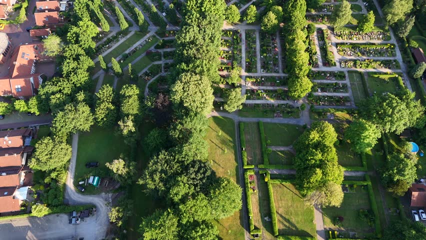 Peaceful and idyllic cemetery with graveyards and tombs in America. Sunny day with green plants in summer. Aerial top down flyover.
