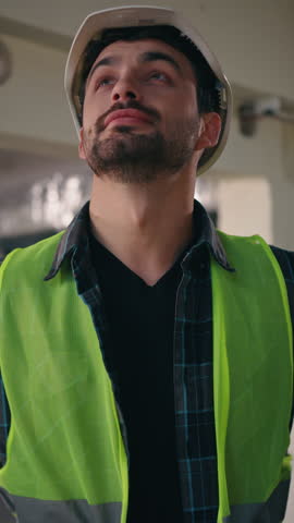 Happy proud Caucasian guy holding hands on hips in construction manufactory architect man technician posing glad electrician male feeling satisfied pleased cheerful inspector contractor admiring work