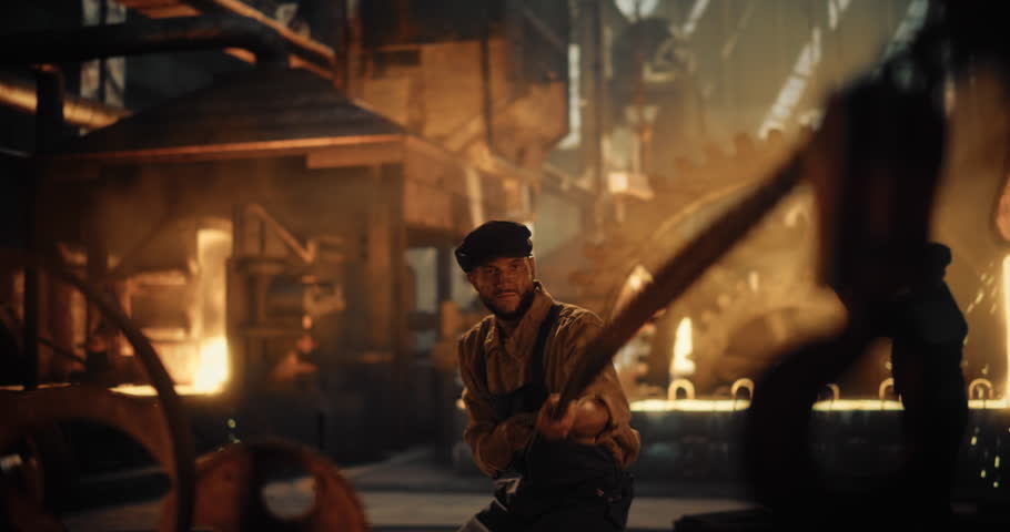 Industrial Workers at an Historical Iron Foundry Handle Molten Metals with Primitive Tools. Man is Pulling a Chain. Smoky, Intense Atmosphere Lit by Orange Glow of Industrial Furnaces