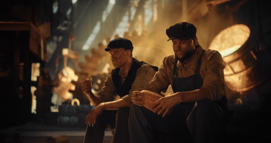 Two 19th-century Foundry Workers Sit Side by Side, Sharing a Simple Loaf of Bread During a Break. One Worker is Smoking a Cigarette. Their Faces are Tired and Soot-Covered, Reflecting the Furnace Glow