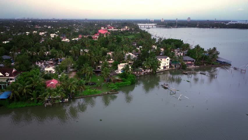 Aerial drone shot of Kochi city, Kerala, India, showcasing a mix of urban infrastructure, residential neighborhoods, and abundant greenery near the scenic backwaters