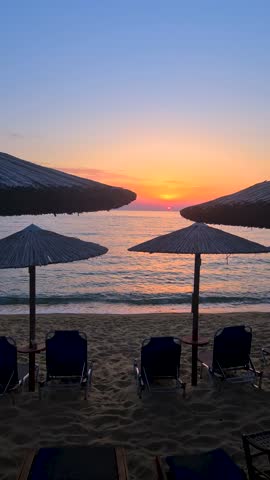Vertical View, Sunset Above Sea Horizon, Sandy Beach With Empty Chairs and Parasols