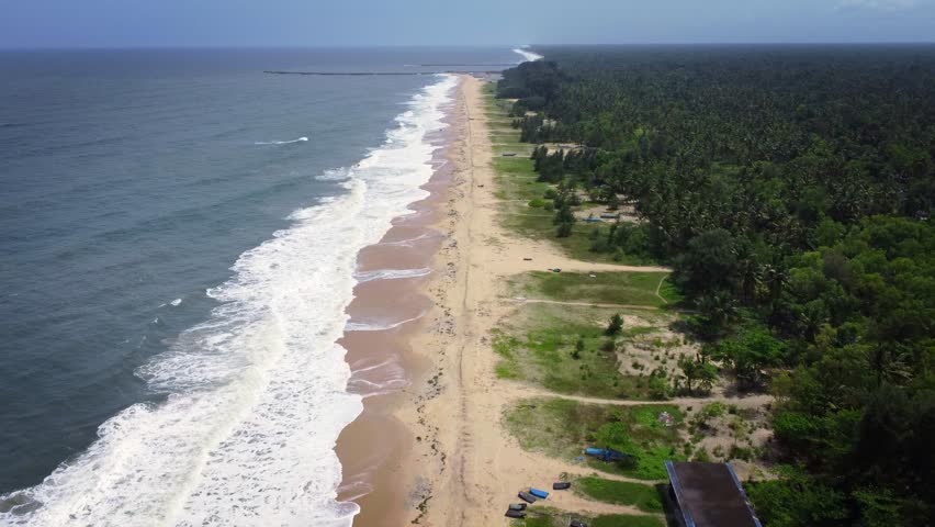 Aerial 4K drone view of the stunning coastline of Alappuzha (Alleppey), Kerala, India, showcasing the tranquil Arabian Sea, golden sandy beach, and lush greenery of this tropical paradise.	