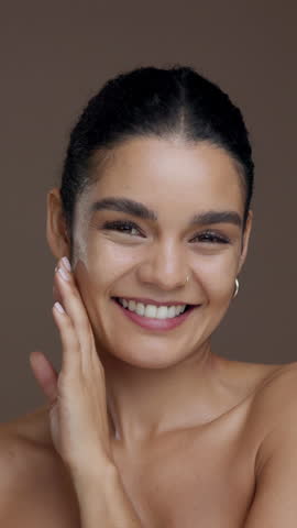 Face, beauty and skincare with woman in studio for wellness, natural glow or clear skin on background. Results, satisfaction and person with dermatology with touching, shine and cosmetic portrait