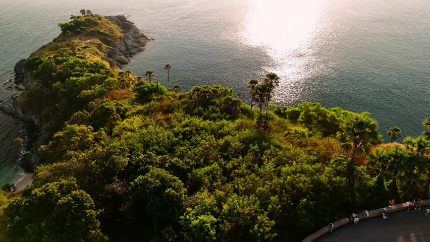 Phromthep cape in Phuket, Thailand, lush tropical vegetation meeting the turquoise Andaman sea at sunset