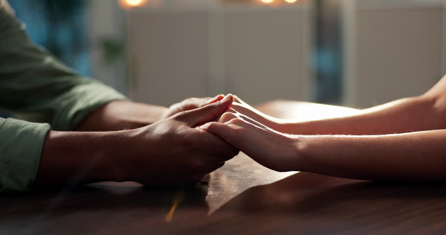 Couple, love and holding hands on table for support, care and commitment with partner on date. Man, woman and comfort with trust for bonding together, respect or connection for marriage in restaurant