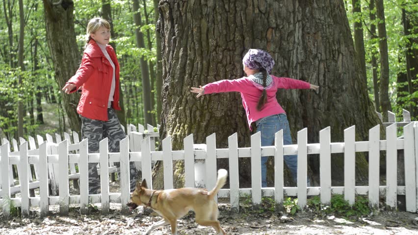 Mom and daughter are trying to clasp hands seven hundred oak trunk