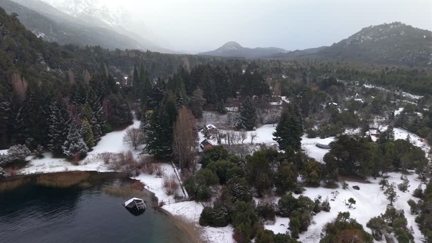 Snowy aerial landscape of Perito Moreno Lake and suburb area with surrounding forest and mountains, Bariloche, Argentina.