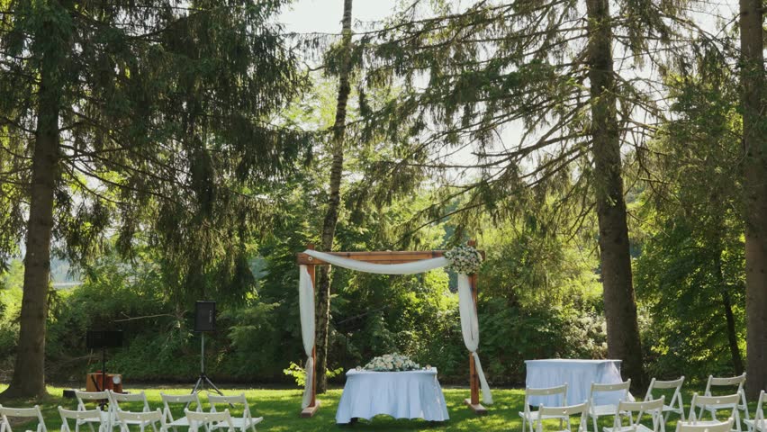Forest wedding reception, table set and guest chairs arranged.