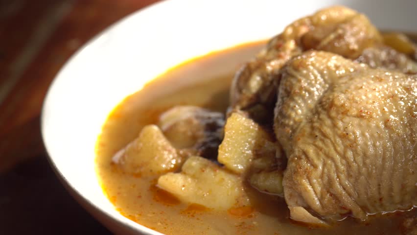 Thai tradition food : Massaman Curry is popular Thai food. Chicken curry with coconut milk, chili, and spicy herbs. Served with steam jasmine rice and fried egg. Dolly scenes of curry meal. Close up.