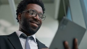 Close up African American happy smiling business man in office using graphics digital tablet computer device smile carefree ethnic male businessman guy worker browsing touchscreen online work internet - Powered by Shutterstock - Get 15% off with code: PIKWIZARD15