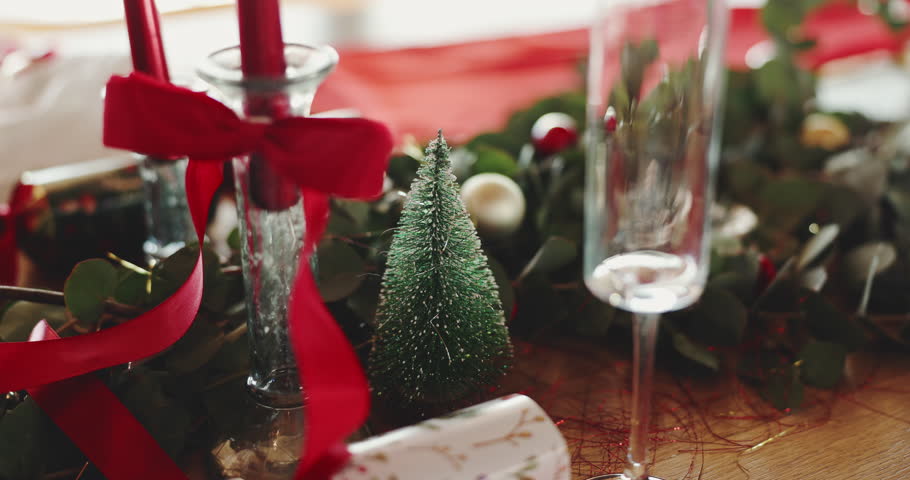 Christmas, decorations and table setting in dining room for festive celebration, event or lunch. Holidays, champagne glass and tableware for xmas party with social gathering in December in home