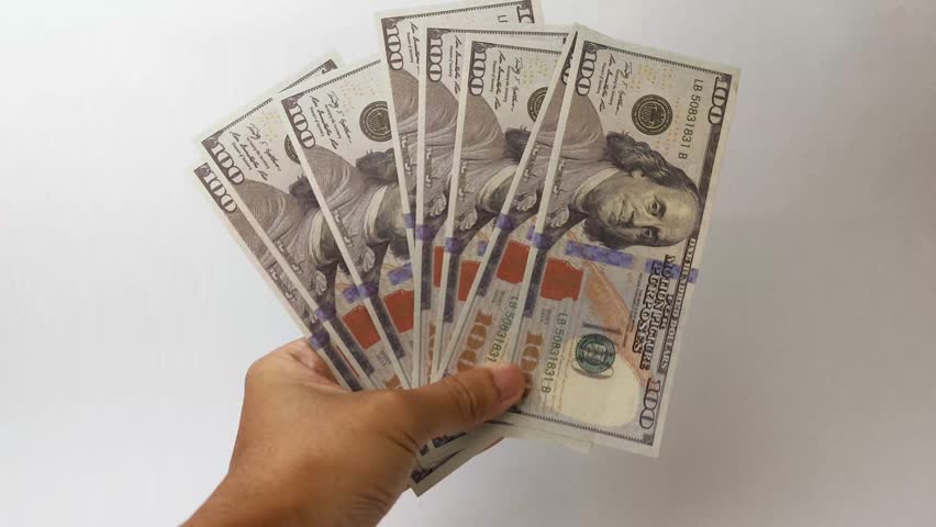 man holding a bunch of dollar bills swinging them slowly against a white background