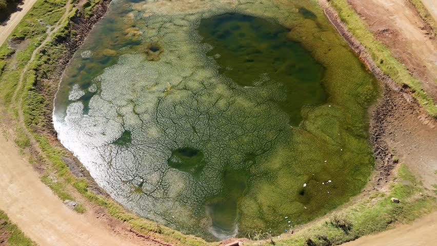 An aerial drone shot captures a high-altitude pond near Raqch
