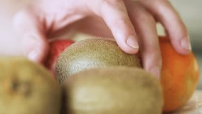 Close up of man grabs fresh fruit from a bowl on kitchen counter. Natural light highlights healthy lifestyle and clean home interior. - Powered by Shutterstock - Get 15% off with code: PIKWIZARD15