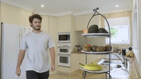 Man grabs fresh fruit from a bowl on kitchen counter. Natural light highlights healthy lifestyle and clean home interior. - Powered by Shutterstock - Get 15% off with code: PIKWIZARD15