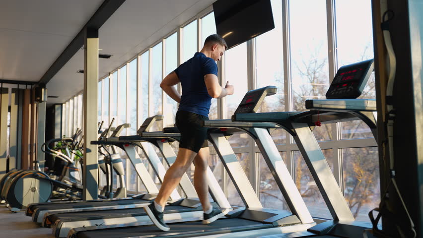 Man running on treadmill at modern gym