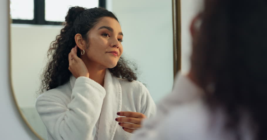 Happy woman, reflection and beauty with mirror in bathroom for skincare, self care or love in home. Female person, satisfaction and blowing kiss with smile for grooming, hygiene or facial in house