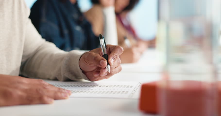 Hands, person and student writing test in classroom for answer, exams and assessment. Learner, document and information for college quiz, question paper and multiple choice for learning at university