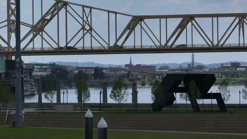 Public park green space beside Ohio river in Louisville, Kentucky with view of bridges