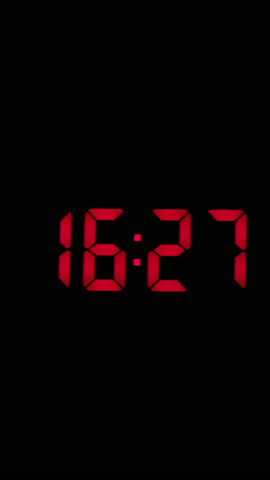 Vertical time lapse of a digital alarm clock time passing over a day to night.