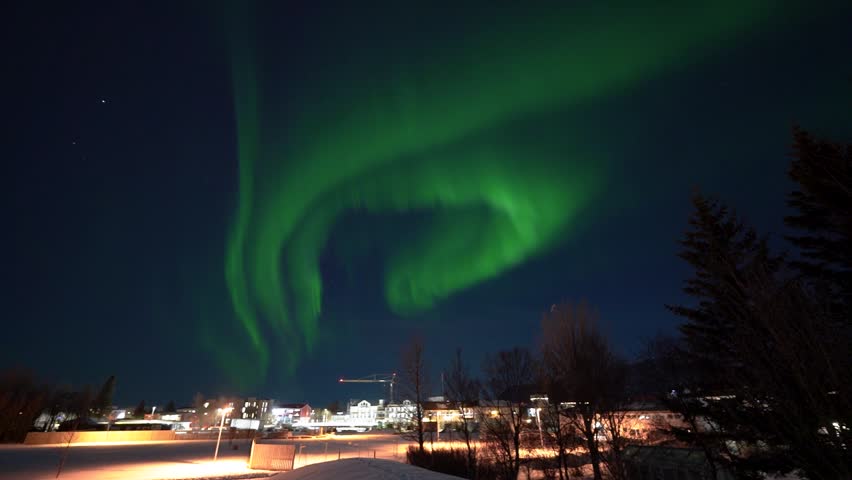 Timelapse of incredible green glowing northern lights dancing and swirling through the dark, night sky in Iceland over Selfoss