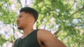 Focused African American athlete catching his breath after intense physical training, captured in a close-up shot under tree shade in an outdoor park - Powered by Shutterstock - Get 15% off with code: PIKWIZARD15