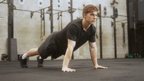 Determined blonde athlete performing perfect form push-up exercise on black rubber flooring in minimalist fitness facility - Powered by Shutterstock - Get 15% off with code: PIKWIZARD15