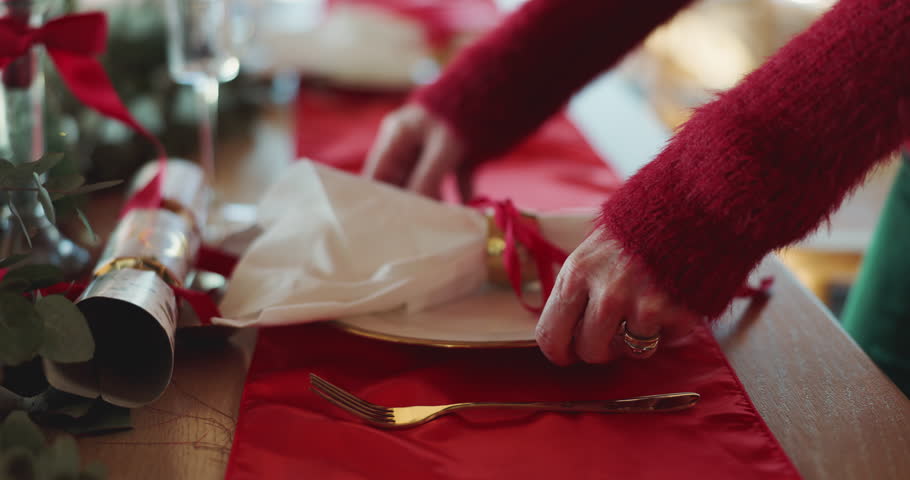 Christmas, hands and set table with napkin for dinner preparation, holiday celebration or decoration. Woman, plate and cutlery for xmas in home dining room, festive season and hospitality for event