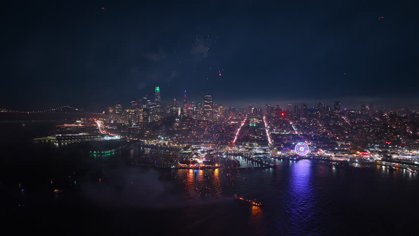 Aerial footage captures fireworks above the iconic skyline of San Francisco on July 4 Independence Day in California USA with a sweeping city view glowing in celebration and festive spirit across bay
