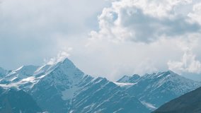 4K Time lapse of clouds moving over snowy mountains and sunrays moving at Lahaul, Himachal Pradesh, India. Snow and glacier on high Himalayan peaks. Monsoon clouds background. Nature landscape. - Powered by Shutterstock - Get 15% off with code: PIKWIZARD15