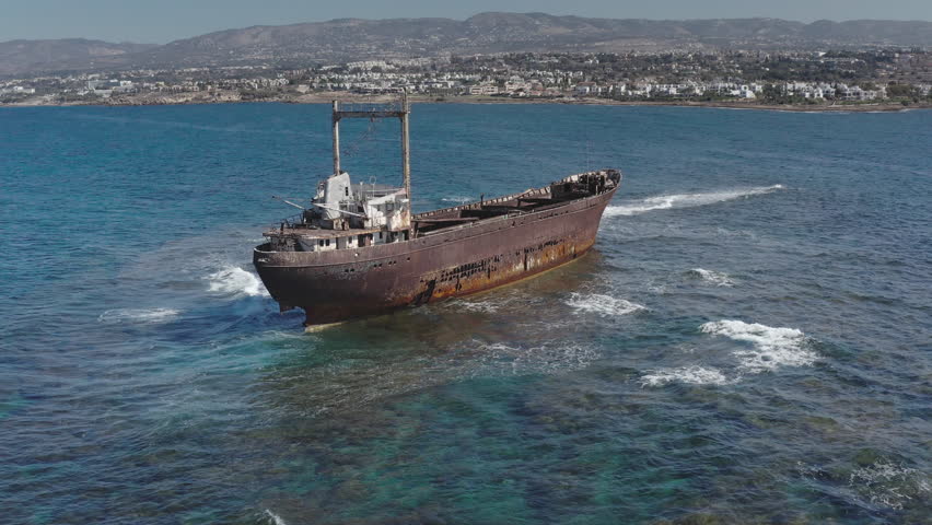 Cyprus: Aerial drone view of the iconic Edro III shipwreck slowly rusting near Peyia, Paphos, Cyprus, a popular tourist attraction showcasing maritime history and decay. Drone flight footage