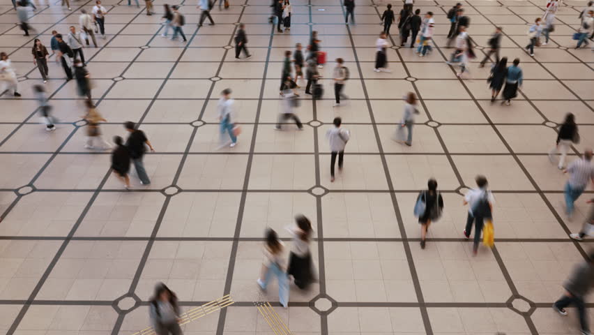 Timelapse of crowd of people walking on a tiled floor in Japan.