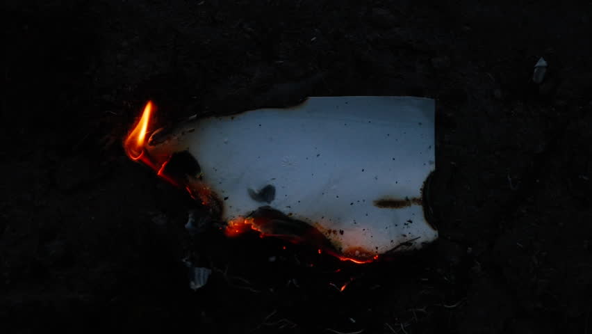 Burning and glowing photo or paper with fire flame and smoke on dark background