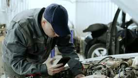 Professional mechanic carefully checking vehicle engine, using smartphone for diagnostic imaging within high tech automotive workshop environment - Powered by Shutterstock - Get 15% off with code: PIKWIZARD15