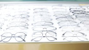 A rows of eyeglasses on display in a shop. stand with glasses in an optics store. Eyesight correction. - Powered by Shutterstock - Get 15% off with code: PIKWIZARD15