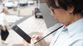 Asian senior reading smartphone message on street close up. Chinese elderly lady browsing social media on mobile phone. woman pensioner looking cellphone screen. - Powered by Shutterstock - Get 15% off with code: PIKWIZARD15