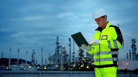 Male petrochemical industry engineer working on laptop computer inspection petroleum oil refinery plant construction site at night. Industrial engineer technician maintaining energy power gas system. - Powered by Shutterstock - Get 15% off with code: PIKWIZARD15