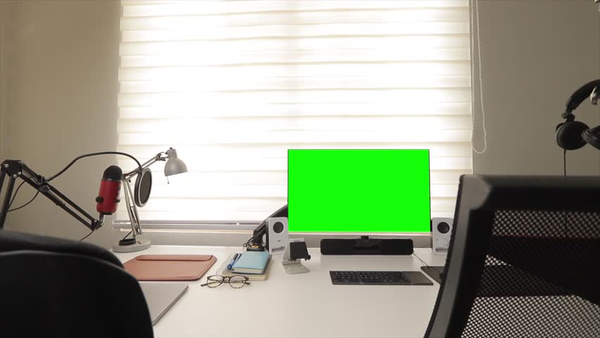 close up zoom in angle movement view the pc desktop computer monitor with green screen monitor on clean table in a office room template placeholder product promotion digital asset design greenscreen