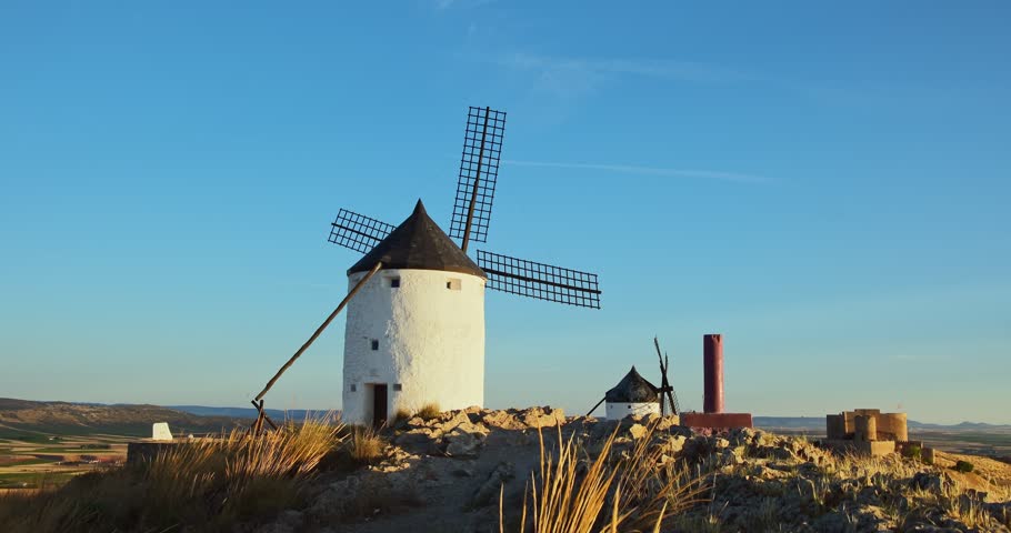 Revealing view of the historic windmills of Consuegra at sunset, Castilla-La Mancha, Spain. Old windmills of Don Quixote character on the hills in evening light. Molinos de Viento de Consuegra