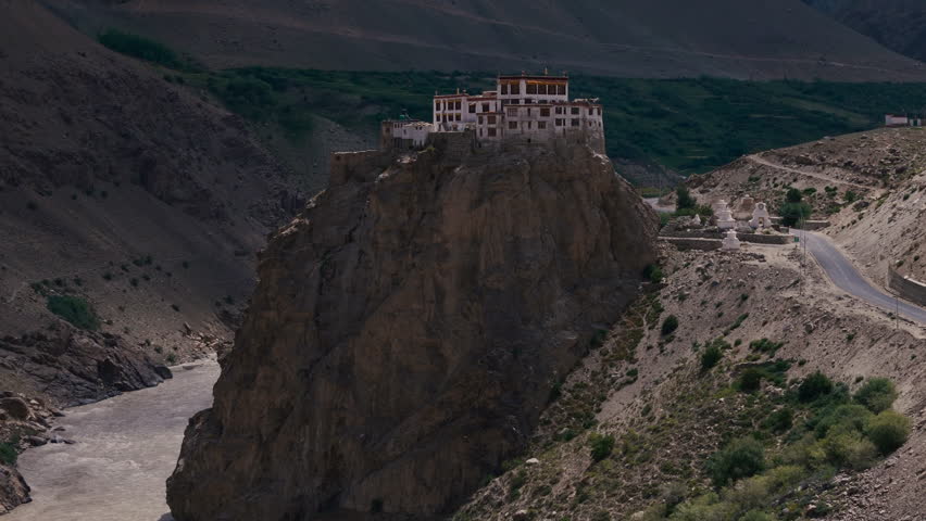 Cliffside Buddhist Monastery with Stupas above River in Himalayas Drone View