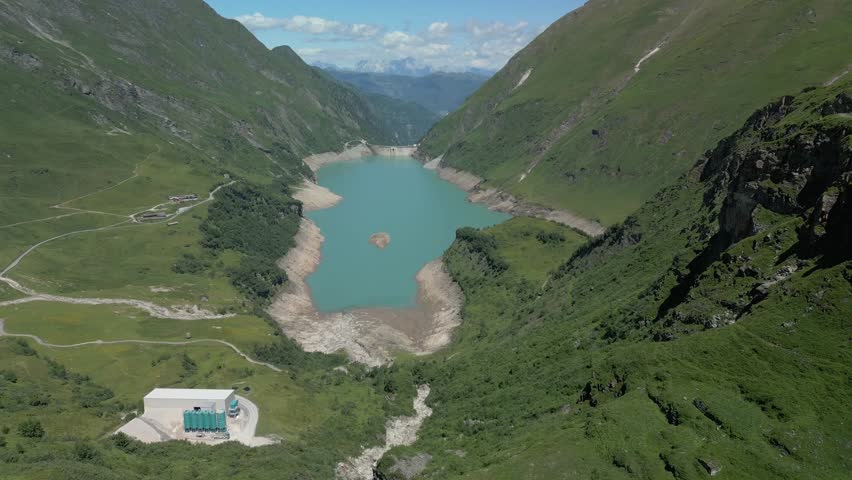 A drone view of Stausee Mooserboden, a striking high-altitude reservoir surrounded by rugged alpine peaks near Kaprun, Austria