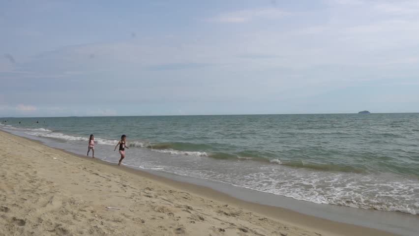 Carefree children play and splash on a sunlit sandy beach during the summer holiday, capturing joyful freedom, seaside fun, and warm vacation vibes.