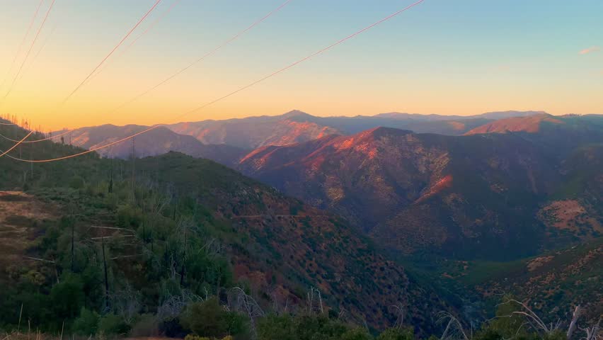 4K Panoramic Street-Level View of Yosemite Mountains at Sunset with Red-Glowing Peaks