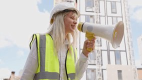 Construction worker leads project team with megaphone at urban site during sunny morning hours - Powered by Shutterstock - Get 15% off with code: PIKWIZARD15