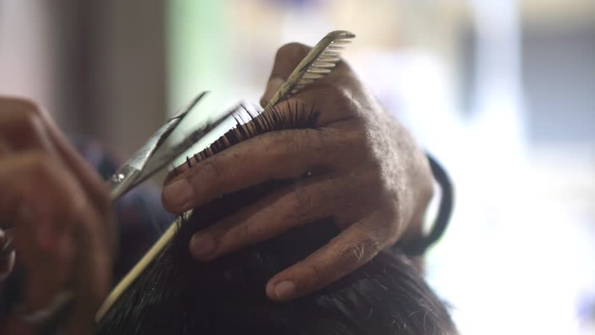 Traditional haircut technique using scissors and comb by an experienced hairdresser