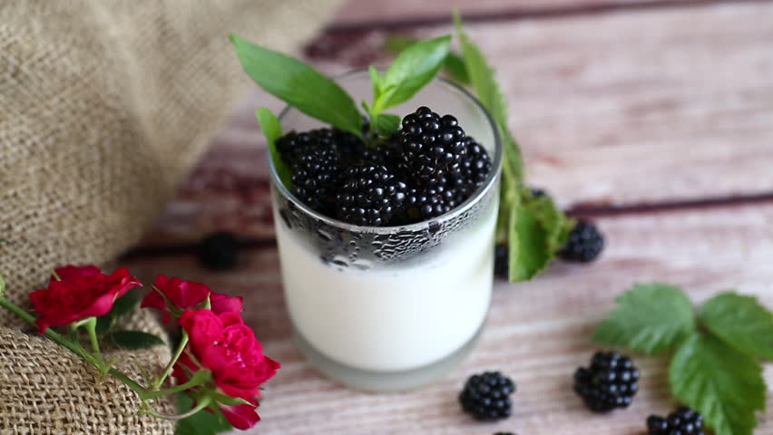 Natural yogurt with blackberries and fresh leaves
