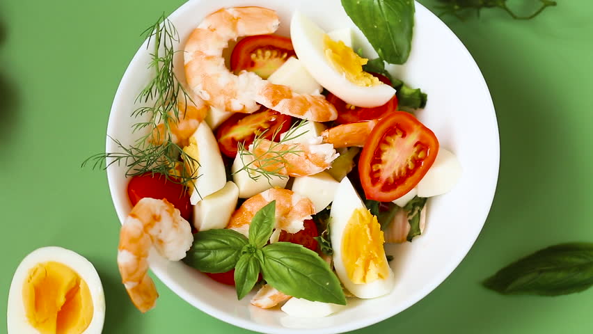 Salad with protein and greens on a green background