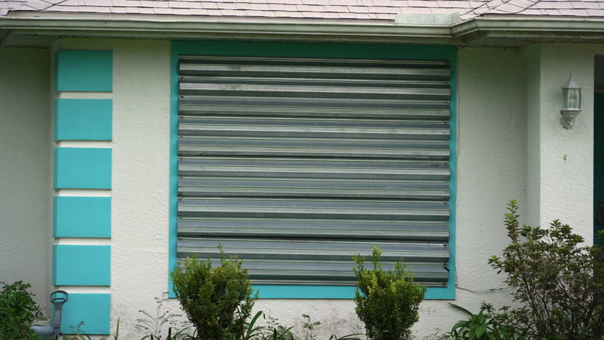 Boarded windows with storm shutters for hurricane protection of Florida home. Protective measures before natural disaster
